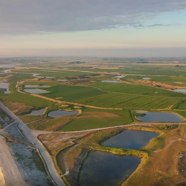 Vue aérienne sur le Hâble d'Ault durant le soleil couchant, seul le cordon de galet sépare le Hâble de la mer